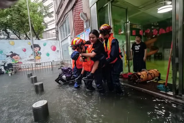 This photo taken on September 4, 2023 shows rescue personnel evacuating a woman in a flooded area from heavy rains caused by Typhoon Haikui in Xiamen, in southern China's Fujian province. (Photo by AFP Photo/China Stringer Network)