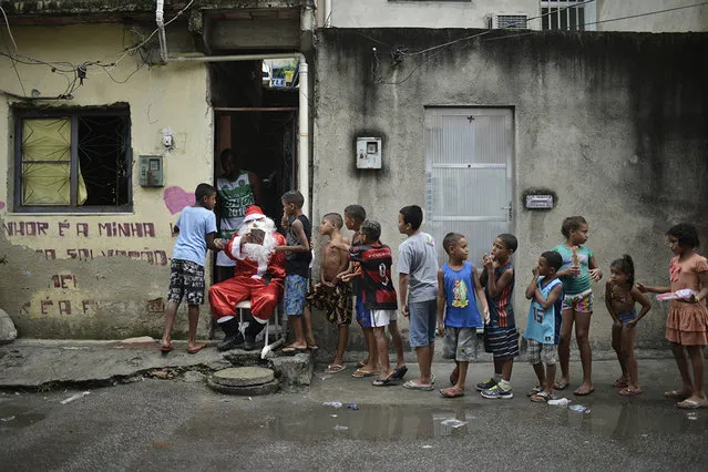 Leandro Souza, 28, who lives in the favela da Mare complex, one of the most violents in Rio de Janeiro, dresses as Santa Claus to distribute gifts to the children of the community in Rio de Janeiro, Brazil on December 17, 2016. (Photo by Fabio Teixeira/AFP Photo)