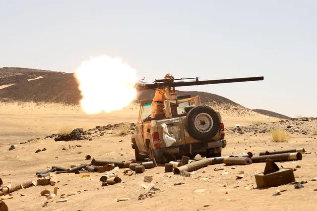 A Yemeni government fighter fires a vehicle-mounted weapon at a frontline position during fighting against Houthi fighters in Marib, Yemen on March 9, 2021. (Photo by Ali Owidha/Reuters)