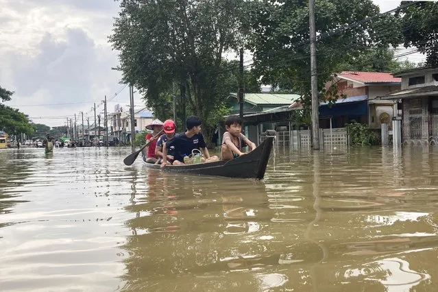 Local residents ride in a boat to down a flooded road in Bago, Myanmar, about 80 kilometers (50 miles) northeast of Yangon, Friday, August 11, 2023. (Photo by AP Photo/Stringer)
