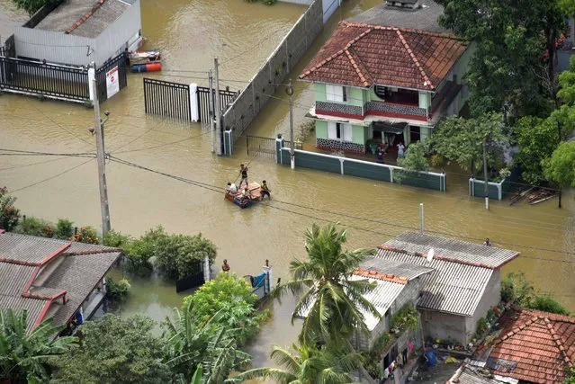 An aerial view shows people making their way through a flooded area in the suburbs of Colombo, Sri Lanka on June 6, 2021. (Photo by Sri Lanka Air Force Media/Handout via Reuters)