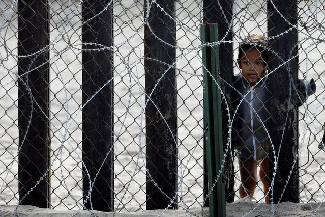 A child looks through the border wall on the Mexico side towards the United States at Border Field State Park in San Diego, California, U.S., November 28, 2018. (Photo by Chris Wattie/Reuters)
