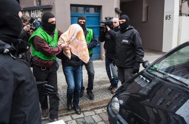Police escort a man who was arrested during a raid on February 4, 2016 in Berlin. German police have arrested two Algerians they suspect of links to the Islamic State group and are hunting for two others in operations in Berlin and other regions, they said Thursday. (Photo by Odd Andersen/AFP Photo)