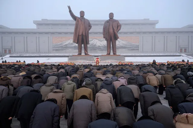Pyongyang residents bow before the statues of late North Korean leaders Kim Il Sung and Kim Jong Il during National Memorial Day on Mansu Hill in Pyongyang on December 17, 2018. North Korea is marking the seventh anniversary of the death of Kim Jong Il. (Photo by Kim Won Jin/AFP Photo)
