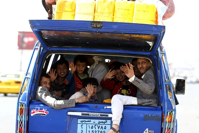 Boys wave from a vehicle as they flee Sanaa with their family and belongings, fearing renewed air strikes, April 2, 2015. Yemen's Houthi fighters and their allies seized a central Aden district on Thursday striking a heavy blow against the Saudi-led coalition which has waged a week of air strikes to try to stem advances by the Iran-allied Shi'ite group. (Photo by Mohamed al-Sayaghi/Reuters)