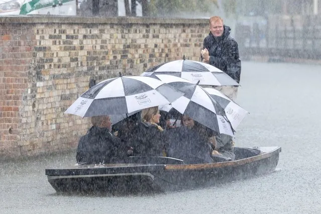 Picture dated October 19th, 2023 shows tourists getting a soaking as they go for a punt in a downpour on the River Cam in Cambridge, UK as Storm Babet arrives. (Photo by Bav Media)
