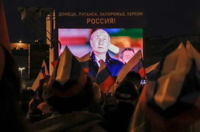 Russian President Vladimir Putin is seen on a screen during a concert marking the declared annexation of the Russian-controlled territories of Ukraine's Donetsk, Luhansk, Kherson and Zaporizhzhia regions, after holding what Russian authorities called referendums in the occupied areas of Ukraine that were condemned by Kyiv and governments worldwide, near the Kremlin and Red Square in central Moscow, Russia on September 30, 2022. A slogan on the screen reads: “Donetsk, Luhansk, Zaporizhzhia, Kherson – Russia!”. (Photo by Reuters/Stringer)
