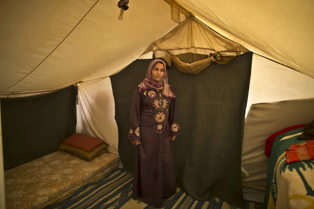 In this Monday, March 16, 2015 photo, Syrian refugee Khalida Moussa, 28, a mother of three children who is six months pregnant, poses for a picture inside her tent at an informal tented settlement near the Syrian border, on the outskirts of Mafraq, Jordan. (Photo by Muhammed Muheisen/AP Photo)
