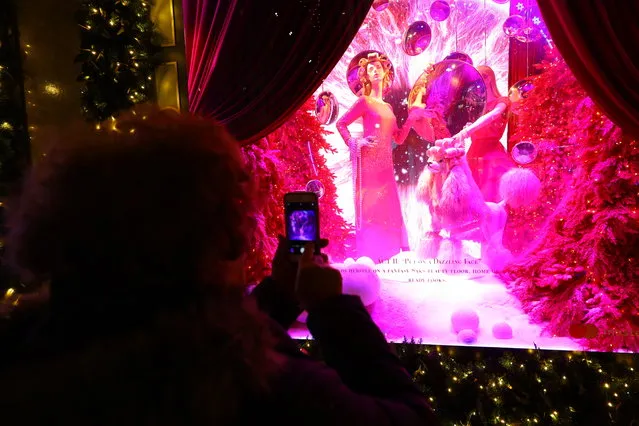 A woman takes a photo of the window display with her mobile device outside Saks Fifth Avenue in New York City on December 19, 2018. (Photo by Gordon Donovan/Yahoo News)
