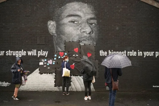 Local residents put messages of support on the plastic that covers offensive graffiti on the vandalised mural of Manchester United striker and England player Marcus Rashford on the wall of a cafe on Copson Street, Withington on July 12, 2021 in Manchester, England. Rashford and other Black players on England's national football team have been the target of racist abuse, largely on social media, after the team's loss to Italy in the UEFA European Football Championship last night. England manager Gareth Southgate, Prime Minister Boris Johnson, and the Football Association have issued statements condemning the abuse. (Photo by Christopher Furlong/Getty Images)