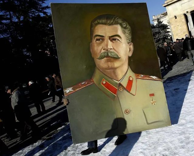 A man carries a portrait of Soviet dictator Josef Stalin as people attend a gathering marking the 130th anniversary of his birthday in Stalin's hometown of Gori, some 50 miles west of Tbilisi, Georgia, on December 21, 2013. (Photo by David Mdzinarishvili/Reuters)