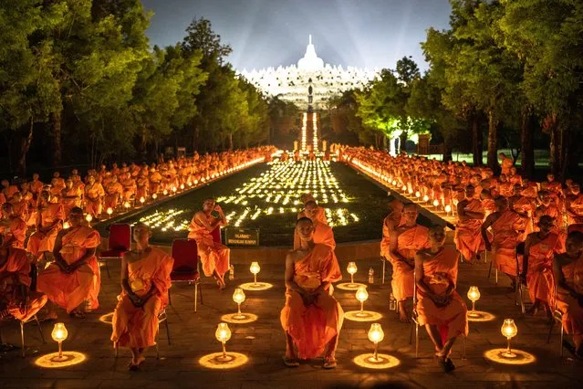 Buddhist monks attend candlelight and lantern flights ceremony during the annual 'Pabbaja Samanera' ritual, a 13-day moral and spiritual training for prospective monks at Borobudur Temple in Magelang, Indonesia on December 23, 2023. Pabbajja Samanera is a sacred event that involves temporary training for aspiring monks. The event is not only a spiritual immersion but also a celebration of unity, attracting participants from Indonesia and around the globe. Around 500 monks attend this sacred ritual from Indonesia, Laos, America, Inggris, and Thailand at the Borobudur Temple. (Photo by Garry Andrew Lotulung/Anadolu via Getty Images)