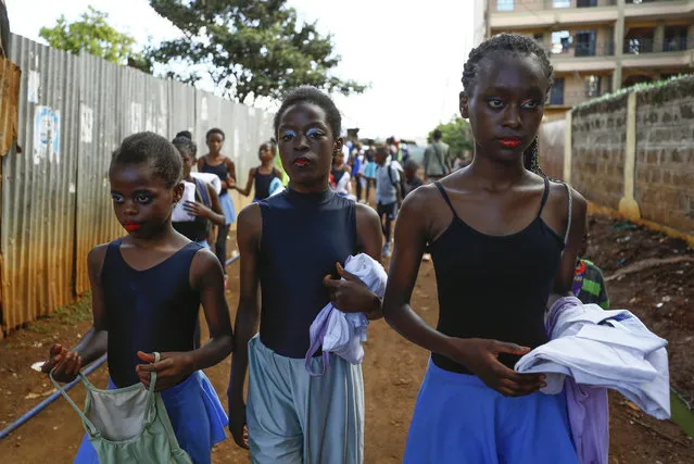 Young dancers walk to participate in a Christmas ballet event, in Kibera,  one of the busiest neighborhoods of Kenya's capital, Nairobi, Friday, December 15, 2023. The ballet project is run by Project Elimu, a community-driven nonprofit that offers after-school arts education and a safe space to children in Kibera. (Photo by Brian Inganga/AP Photo)