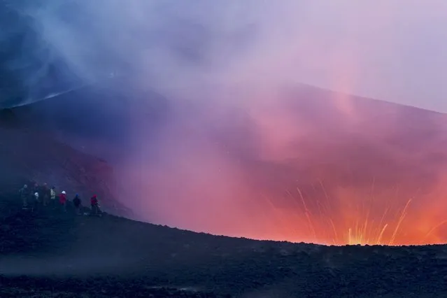 A group of tourists overlook the huge volcano crater. (Photo by Denis Budkov/Caters News)