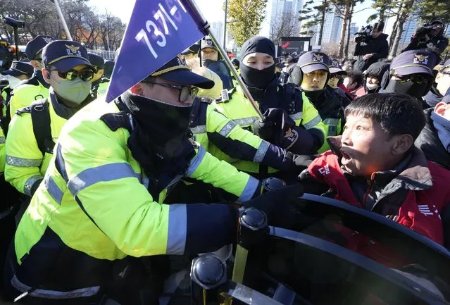 A dog farmer struggles with police officers during a rally against the government-led dog meat banning bill in front of the presidential office in Seoul, South Korea, Thursday, November 30, 2023. (Photo by Ahn Young-joon/AP Photo)