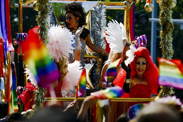 Men in drag costumes wave from a float to participants during the Tokyo Rainbow Pride parade in Tokyo April 26, 2015. (Photo by Thomas Peter/Reuters)
