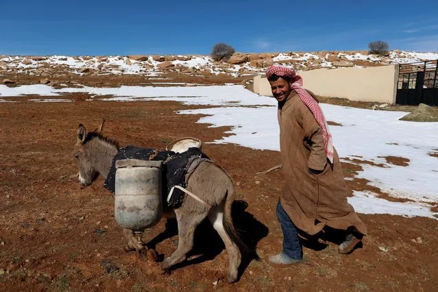 A man smiles as he walks beside his donkey carrying cans of gas butane on the outskirts of Laghouat in the Saharian Atlas Mountains, Algeria January 26, 2017. (Photo by Zohra Bensemra/Reuters)