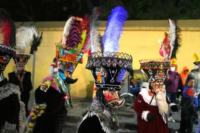 Mexican “chinelo” dancers participate in the procession of “Ninopan” during a Christmas “posada”, which means lodging or shelter, in the Xochimilco borough of Mexico City, Wednesday, December 21, 2022. For the past 400 years, residents have held posadas between Dec. 16 and 24, when they take statues of baby Jesus in procession to church for Mass to commemorate Mary and Joseph's cold and difficult journey from Nazareth to Bethlehem in search of shelter. (Photo by Eduardo Verdugo/AP Photo)