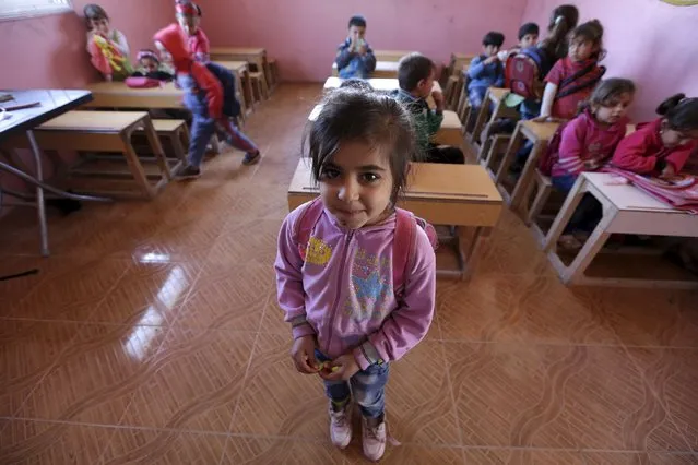 Five-year-old Sandas al-Mohamed poses inside a classroom in the rebel-controlled area of Maarshureen village in Idlib province, Syria March 12, 2016. (Photo by Khalil Ashawi/Reuters)
