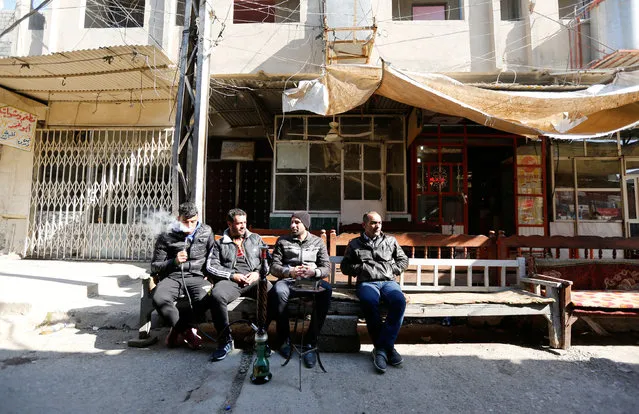 Iraqi men drank waterpipe at a coffee shop in the street of Mosul, Iraq, February 3, 2017. (Photo by Ahmed Saad/Reuters)
