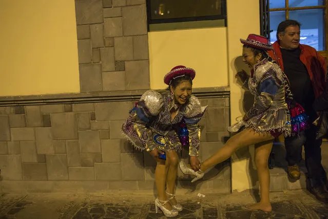 Dancers laugh as the remove their shoes after performing in the Virgin of Candelaria celebrations in Puno, Peru, Sunday, February 5, 2017. (Photo by Rodrigo Abd/AP Photo)