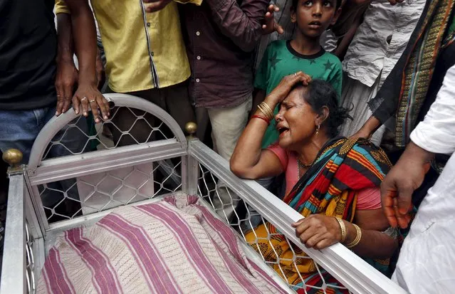 A woman mourns next to the body of Mohammad Ramzani, a cycle rickshaw driver who died after an under-construction flyover collapsed on Thursday, in Kolkata, April 1, 2016. (Photo by Rupak De Chowdhuri/Reuters)