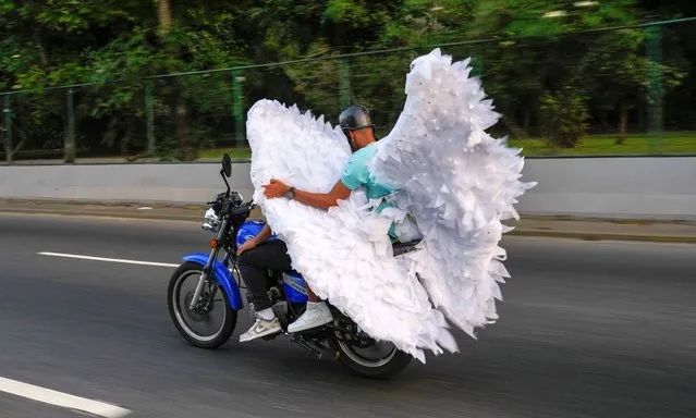 A man carries a wings costume during Carnival in Caracas, Venezuela, Monday, February 12, 2024. (Photo by Ariana Cubillos/AP Photo)