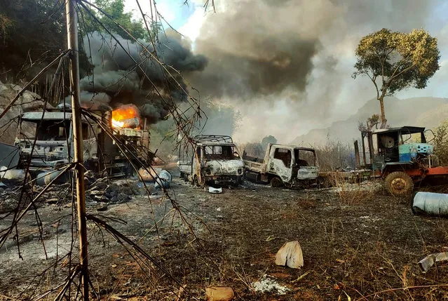 In this photo provided by the Karenni Nationalities Defense Force (KNDF), smokes and flames billow from vehicles in Hpruso township, Kayah state, Myanmar, Friday, December 24, 2021. Myanmar government troops rounded up villagers, some believed to be women and children, fatally shot more than 30 and set the bodies on fire, a witness and other reports said Saturday. (Photo by KNDF via AP Photo)