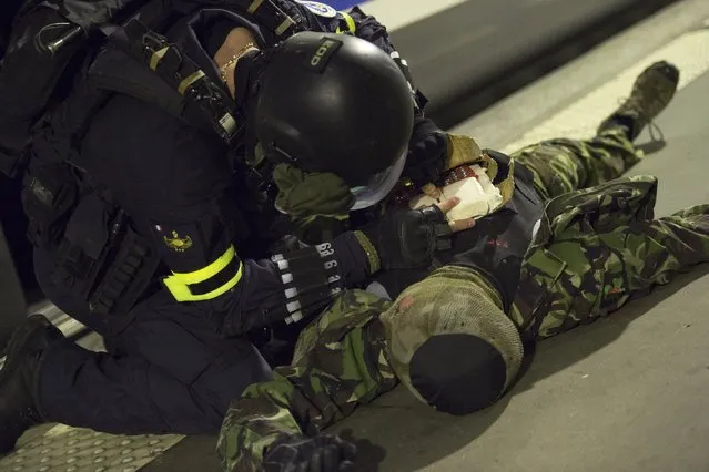 A member of the National Gendarmerie Intervention Group (GIGN) is pictured as he controls one of the supposed terrorists during a training exercise in the event of a terrorist attack in collaboration with Recherche Assistance Intervention Dissuasion (RAID) and Research and Intervention Brigades (BRI) in presence of the French Interior minister Bernard Cazeneuve at la Gare Montparnasse, in central Paris on April 20, 2016. (Photo by Miguel Medina/Reuters)