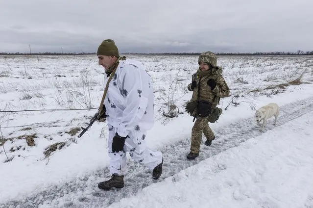 Ukrainian soldiers walk at the line of separation from pro-Russian rebels, Donetsk region, Ukraine, Sunday, January 2, 2022. President Joe Biden has warned Russia's Vladimir Putin that the U.S. could impose new sanctions against Russia if it takes further military action against Ukraine. (Photo by Andriy Dubchak/AP Photo)