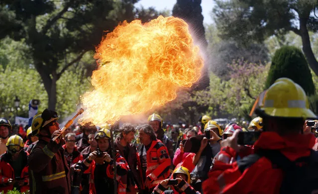 A fireman performs with fire during a protest against budget cuts in front of Catalunya's Parliament in Barcelona, April 10, 2014. (Photo by Albert Gea/Reuters)