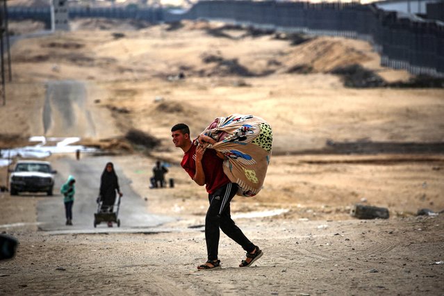 Palestinians carry their belongings as they prepare to flee Rafah in the southern Gaza Strip on May 13, 2024, amid the ongoing conflict between Israel and the Hamas militant group. (Photo by AFP Photo/Stringer)