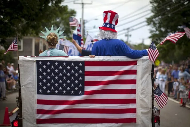 People in costumes ride on a float through Barnstable Village on Cape Cod during the annual 4th of July Parade in Barnstable, Massachusetts, July 4, 2015. (Photo by Mike Segar/Reuters)