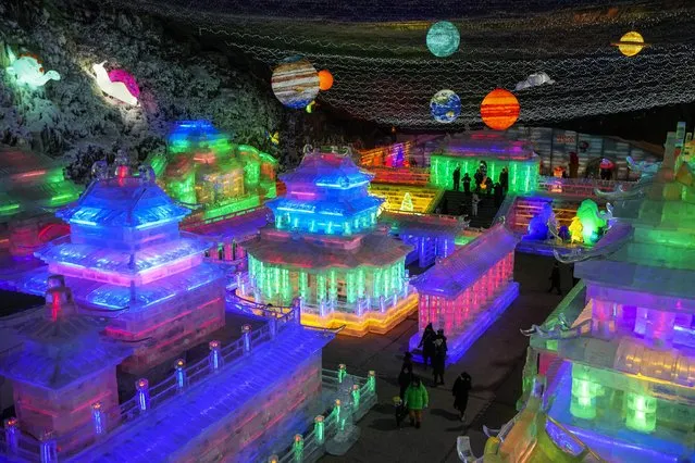 Residents tour the ice sculptures lit by colorful lights at the Longqingxia Ice and Snow Festival, during the Lantern Festival in Yanqing district of Beijing, Tuesday, February 15, 2022. Tuesday marks the Lantern Festival in China, the final day of the annual celebration of the Chinese Lunar New Year. (Photo by Andy Wong/AP Photo)