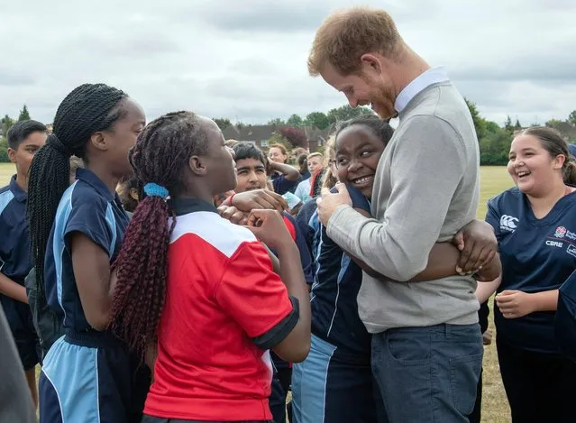 Britain's Prince Harry is hugged by a pupil during a visit the Rugby Football Union All Schools Programme at Lealands High School in Luton, England, Thursday, September 12, 2019. (Photo by Arthur Edwards/Pool Photo via AP Photo)