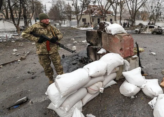 Ukrainian soldiers stand in the aftermath of an overnight shelling at the Ukrainian checkpoint in Brovary near Kiev (Kyiv), Ukraine, 01 March 2022. Russian troops entered Ukraine on 24 February prompting the country's president to declare martial law and triggering a series of announcements by Western countries to impose severe economic sanctions on Russia. (Photo by Sergey Dolzhenko/EPA/EFE)