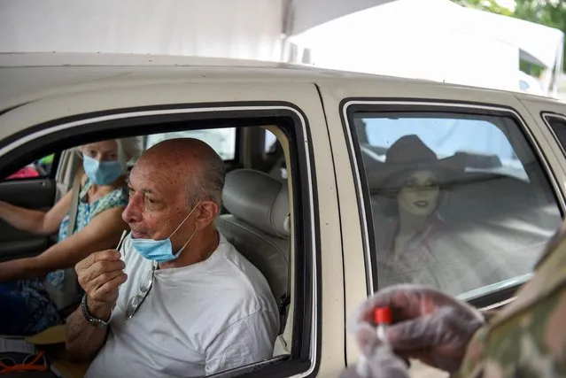 A person uses a nasal swab to provide a sample to be tested for the coronavirus disease (COVID-19) at a drive-thru testing site as cases surge across the state, in New Orleans, Louisiana, U.S., August 6, 2021. (Photo by Callaghan O'Hare/Reuters)