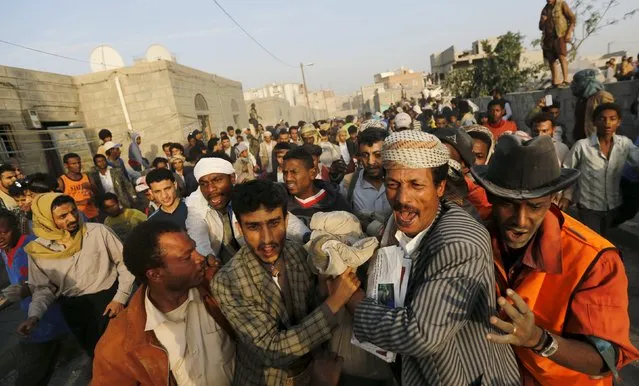 People carry the body of a man they recovered from the site of a Saudi-led air strike in Yemen's capital Sanaa July 13, 2015. Saudi-led air raids killed 21 civilians in Yemen's capital Sanaa on Monday morning, relatives of the victims and medics told Reuters, two days after the start of a United Nations-brokered humanitarian truce that Riyadh does not recognise. (Photo by Khaled Abdullah/Reuters)