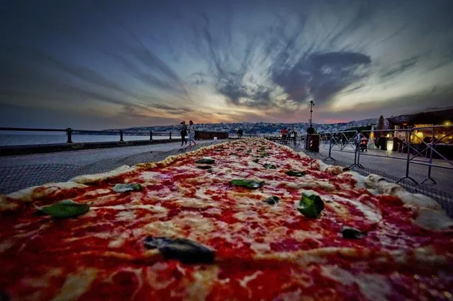 A general view of a Neapolitan pizza made to break the world record for the longest pizza ever made, by making a two kilometers margherita (16 inch wide) pizza stretching along the city waterfront, in Naples, Italy, 18 May 2016. (Photo by Ciro Fusco/EPA)