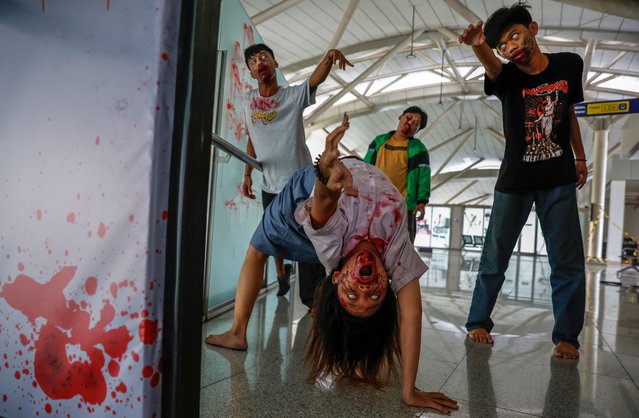 Actors perform as zombies during the “Train to Apocalypse: No Way Out” event at a Light Rail Transit (LRT) train station in Jakarta, Indonesia, 13 July 2024. The Indonesian capital's LRT operator modified train stations into zombie apocalypse settings to promote the use of public transportations and entertain the commuters. (Photo by Mast Irham/EPA/EFE)