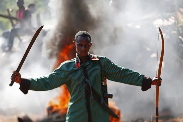 A man gestures in front of a burning barricade during a protest against French soldiers in Bambari May 22, 2014. At least three people were killed in the Central African Republic on Thursday as Muslims with machetes and rifles clashed with French peacekeeping troops trying to disarm rebels, a rebel spokesman said. (Photo by Goran Tomasevic/Reuters)