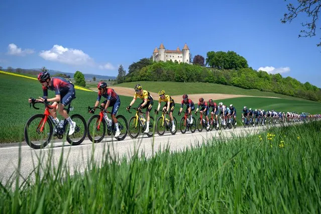 The pack rides past the Champvent Castle during the first stage of the Tour de Romandie UCI World Tour cycling race, 178km from La Grande Beroche to Romont, on April 27, 2022, in Champvent, western Switzerland. (Photo by Fabrice Coffrini/AFP Photo)