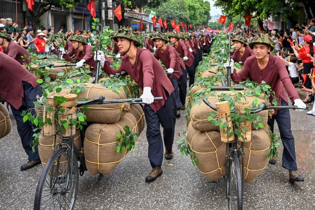 Performers walk with bicycles depicting the transportion of food and necessities for the battlefield during official celebrations of the 70th anniversary of the 1954 Dien Bien Phu victory over French colonial forces in Dien Bien Phu city on May 7, 2024. War veterans, soldiers and dignitaries gathered in Vietnam's Dien Bien Phu on May 7 to mark the 70th anniversary of the battle that ultimately brought an end to the French empire in Indochina. (Photo by Nhac Nguyen/AFP Photo)