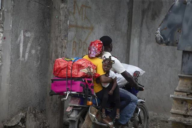 Residents travel on a motorbike as they flee their home to avoid clashes between armed gangs, in the Croix-des-Mission neighborhood of Port-au-Prince, Haiti, Thursday, April 28, 2022. (Photo by Joseph Odelyn/AP Photo)