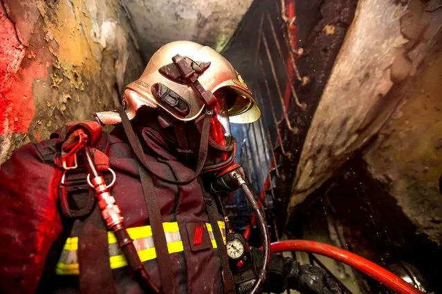 This photo taken on June 6, 2016 and handout on June 7, 2016 by the Paris Fire Brigade (Brigade des Sapeurs Pompiers de Paris) shows a firefighter intervening in a staircase to extinguish a fire in an appartment building in Saint-Denis, north of Paris. A fire broke out on June 6, 2016 in the evening in a residential building in central Saint-Denis, killing at least five and injuring two seriously, according to the Paris Fiure Brigade. (Photo by Erwan Thépault/AFP Photo)