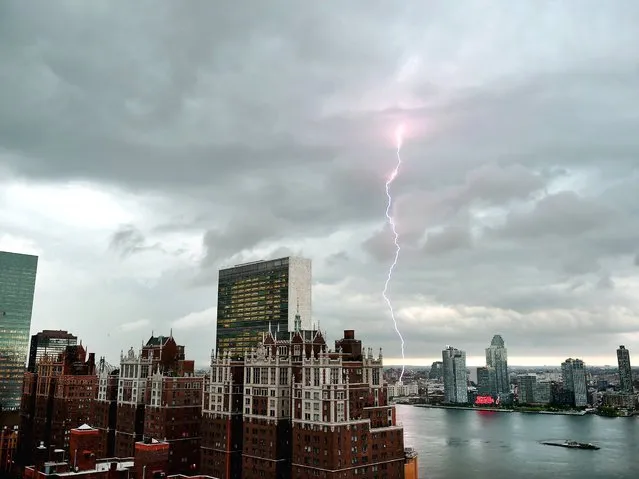 With the United Nations and Tudor City in the foreground, lightning strikes in the sky over the East River as a major storm approaches New York City July 2, 2014. Tropical Storm Arthur, the first of the Atlantic hurricane season, gathered strength July 20, 2014 and would likely reach hurricane strength over the next couple of days. (Photo by Timothy A. Clary/AFP Photo)