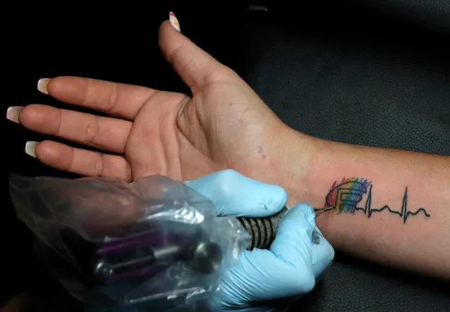Becky Roero gets a tattoo done by Ron Rivera at Stigma Tattoo Bar to raise funds for the families of the victims who were killed at the Pulse gay nightclub in Orlando, Florida, June 18, 2016. (Photo by Jim Young/Reuters)