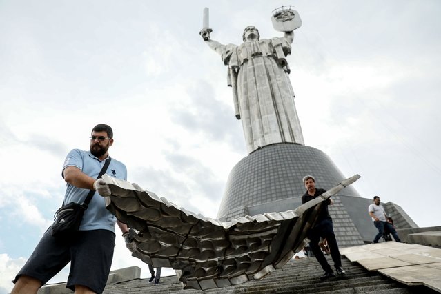 Museum workers carry a part of the Soviet Union coat of arms removed from the Motherland Monument in Kyiv, Ukraine, 30 July 2023. The Ukrainian coat of arms will replace the old Soviet one on the Motherland Monument by Independence Day, which Ukraine will mark on 24 August. Russian troops entered Ukraine on 24 February 2022 starting a conflict that has provoked destruction and a humanitarian crisis. (Photo by Oleg Petrasyuk/EPA/EFE)