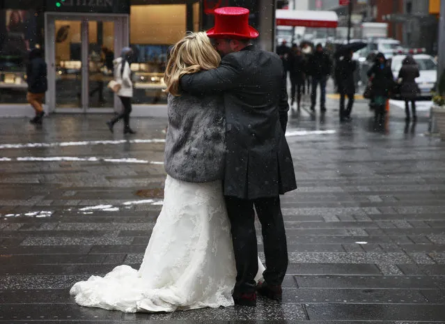 A couple embraces during light snowfall at Times Square in New York January 6, 2015. (Photo by Shannon Stapleton/Reuters)