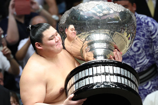 Japanese sumo wrestler Onosato receives the Prime Minister's Cup after finishing 13-2 for the best record to take the championship on the final day of the 15-day Autumn Grand Sumo Tournament in Tokyo on September 22, 2024. (Photo by JIJI Press via AFP Photo)